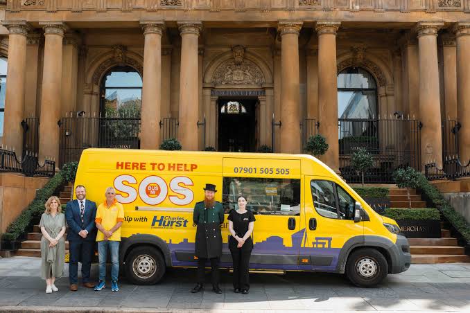 SOS Bus NI bus with partners outside a Belfast building