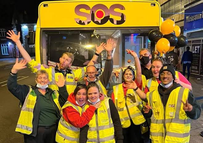 SOS volunteers at night by the bus