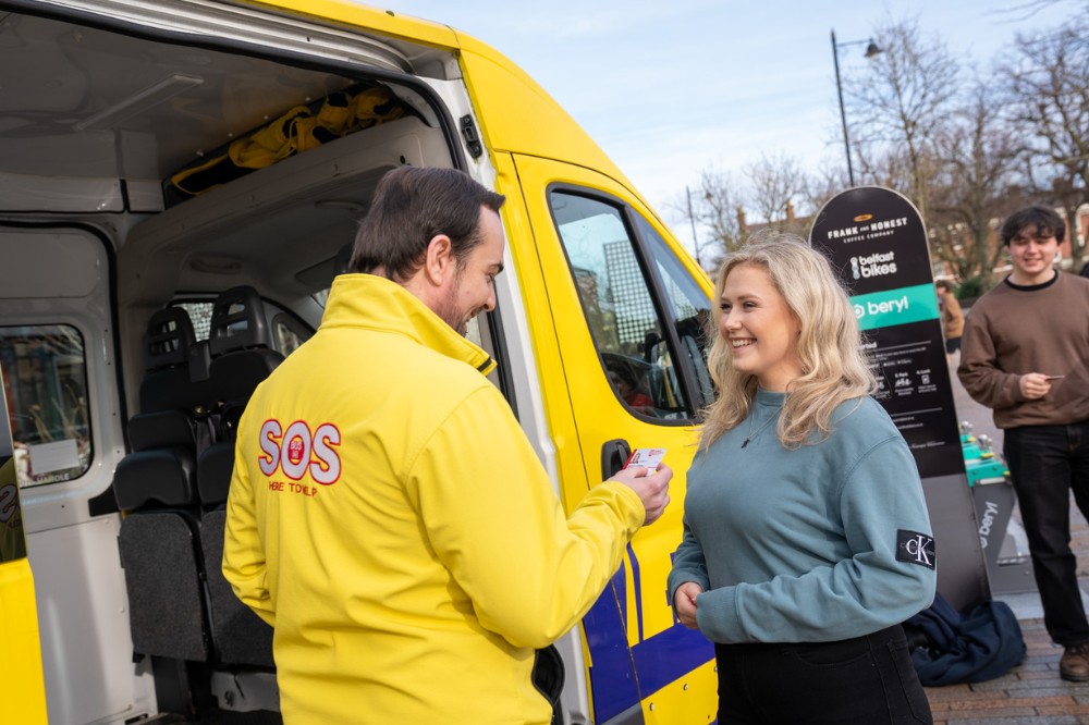 SOS Bus NI volunteer speaking with a member of the public beside the bus